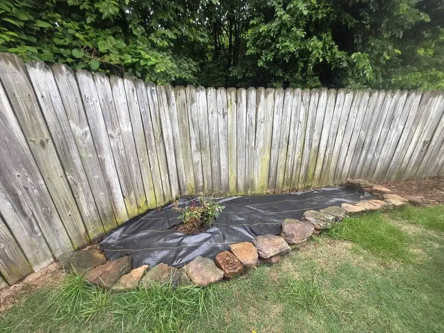 Stone bed built into a fence corner over fabric