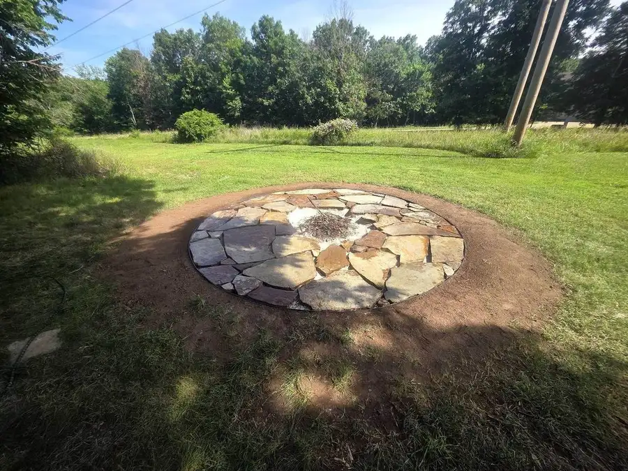 Finished flagstone fire pit ring set into an open lawn