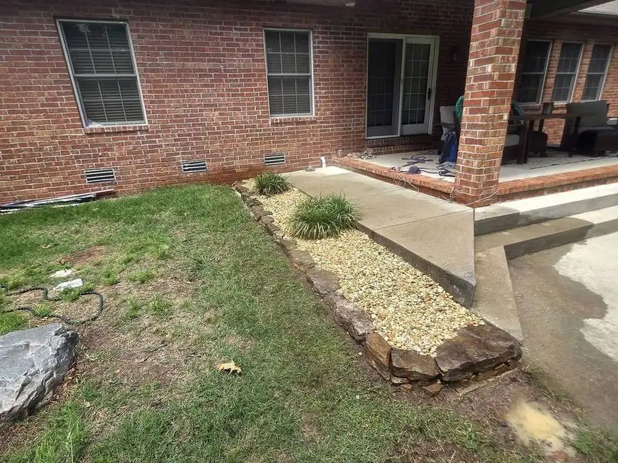 Flagstone fire pit with a brick house behind it