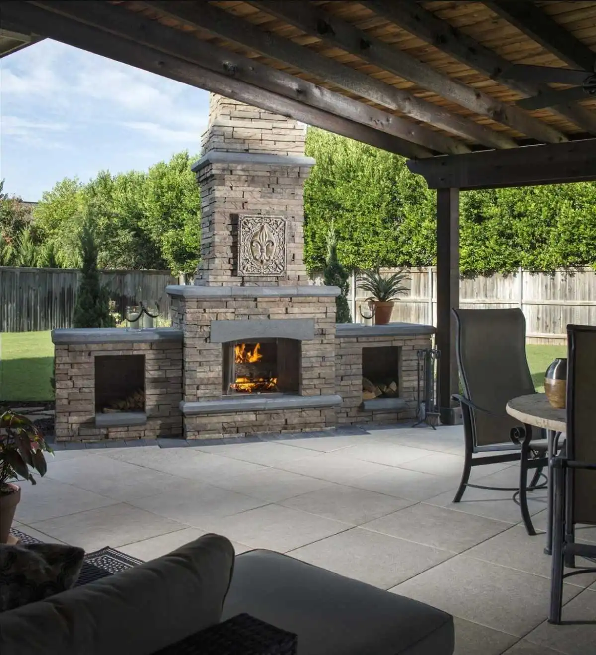 Covered patio with a stone outdoor fireplace