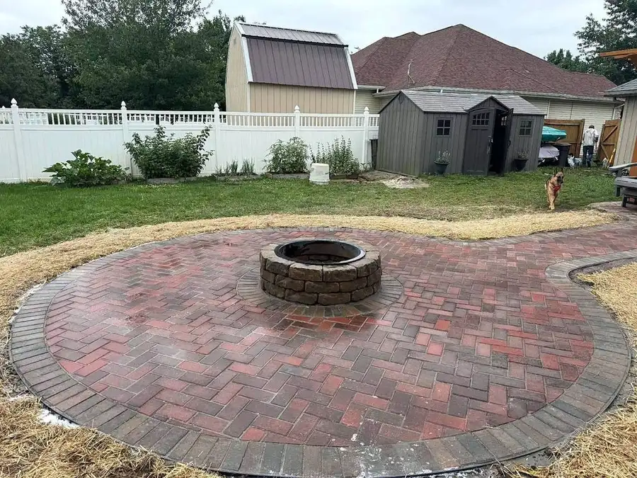 Finished brick paver fire pit patio with a herringbone field