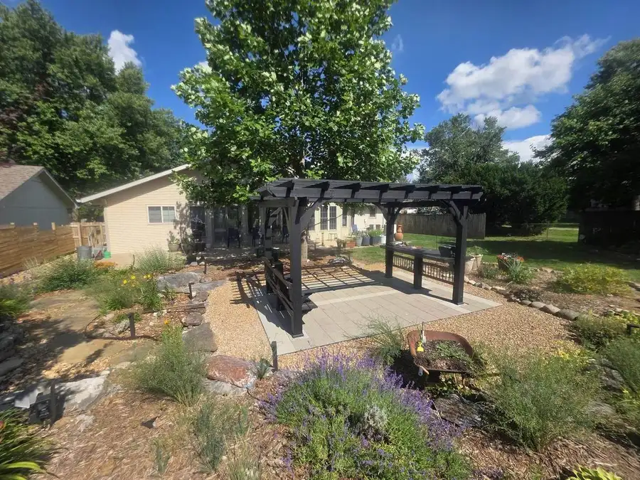 Pergola with stone beds, gravel paths and mature plantings