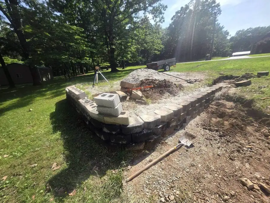 Laser level sitting on a block retaining wall course under construction